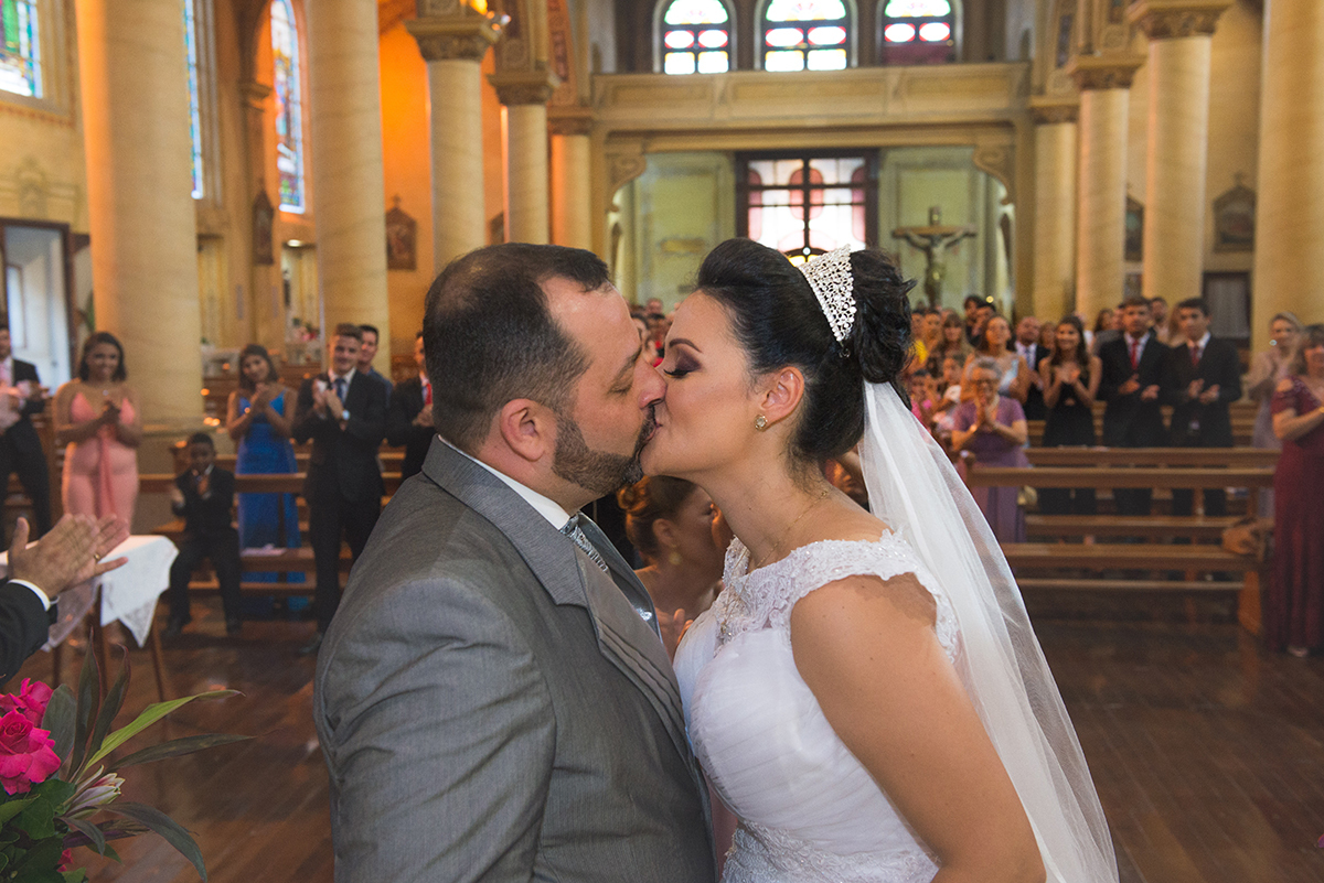 Fotografia do momento do beijo dos noivos na cerimônia de casamento. Foto por Marco Moscarelli