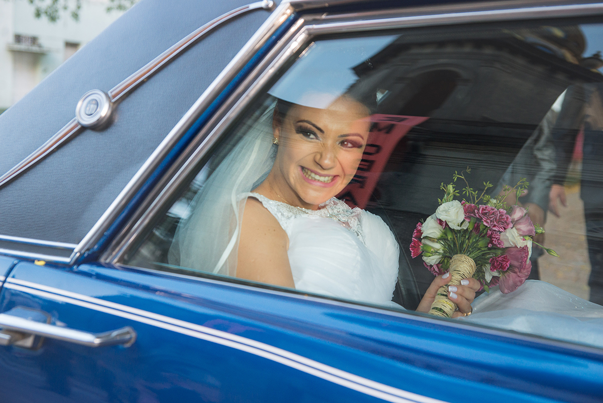 Noiva com um lindo sorriso dentro do carro logo após a cerimônia de casamento. Foto por Marco Moscarelli