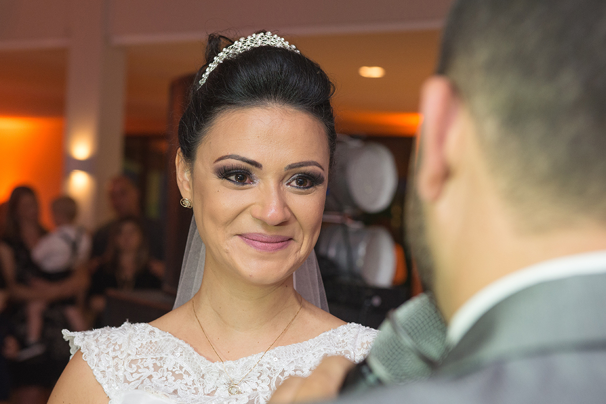 Olhar emocionado da noiva para o noivo durante a recepção dos noivos após o casamento. Foto por Marco Moscarelli