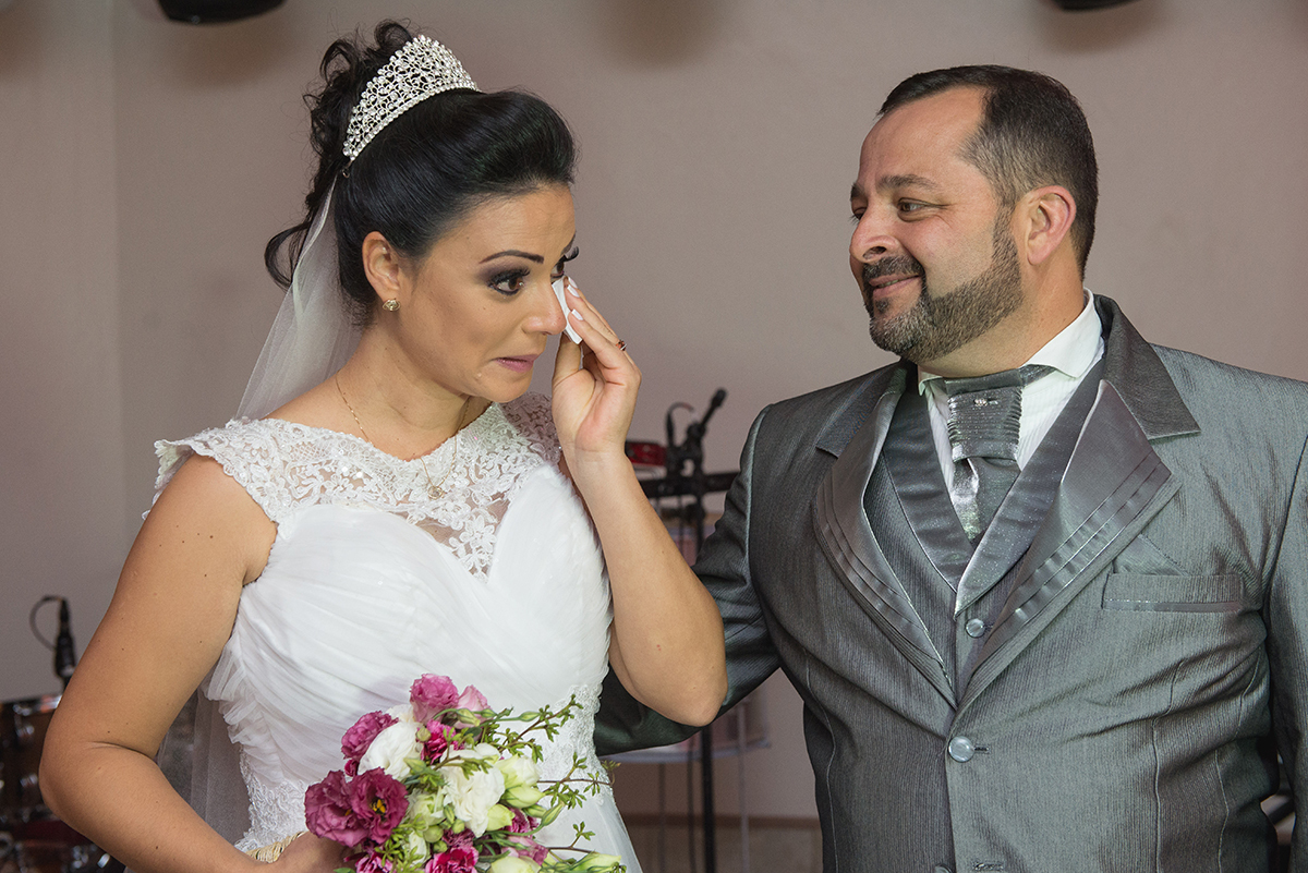 Noiva emocionada olhando para o noivo durante a recepção dos noivos. Foto por Marco Moscarelli