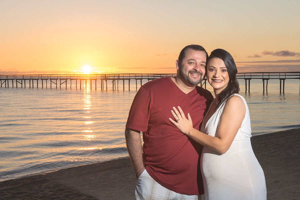 Noivos admirando o nascer do sol na praia do laranjal durante seu ensaio pré-wedding. Foto por Marco Moscarelli