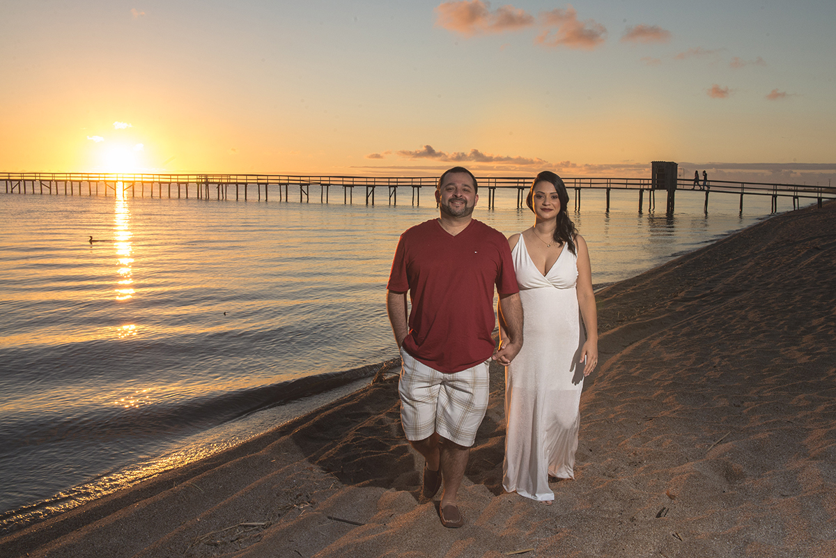 Noivos caminhando na areia da pria do laranjal durante o seu pré-wedding. Foto Por Marco Moscarelli