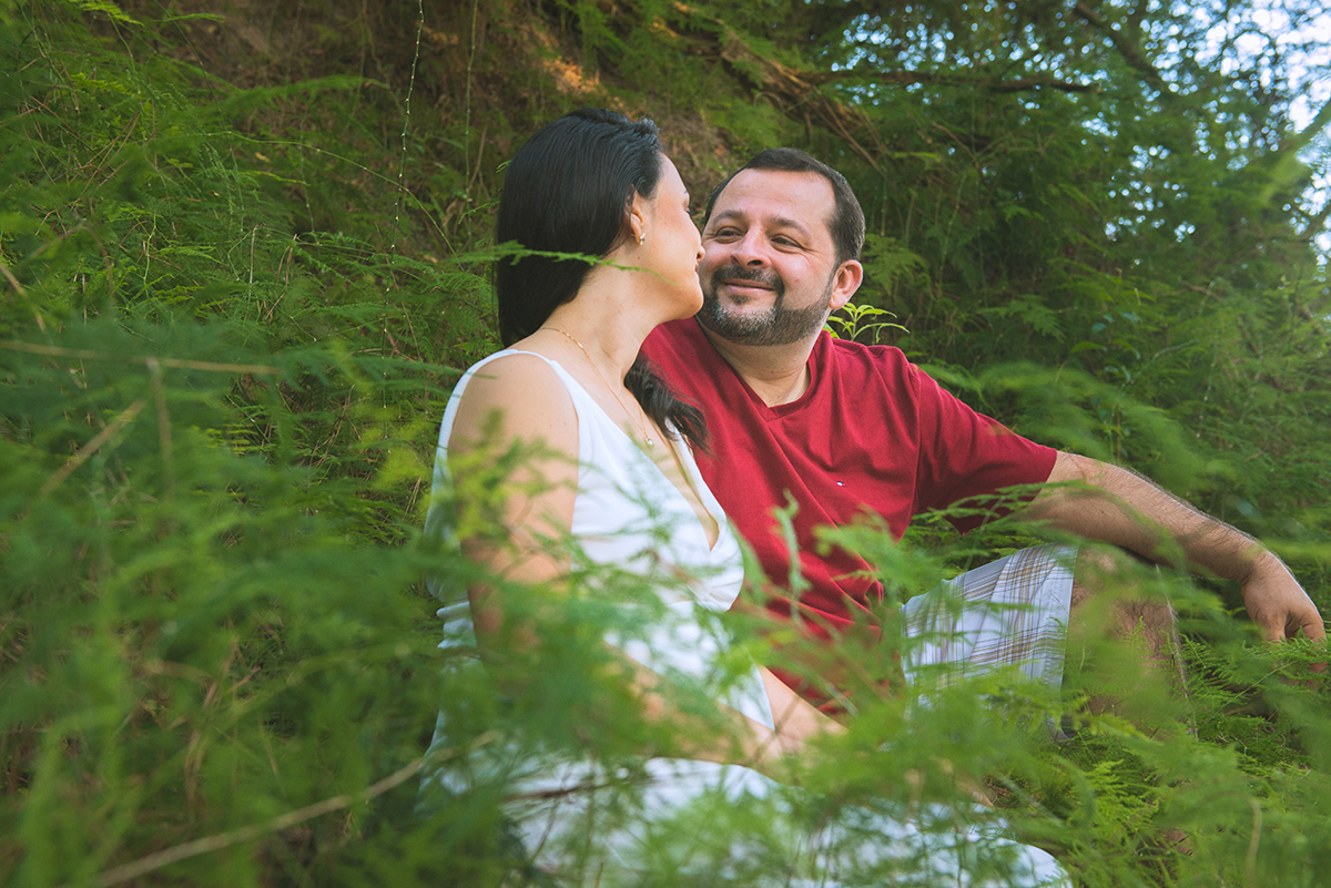 Noivo beija a noiva  em meio a vegetação durante as fotos do seu ensaio de casal pré-wedding. Foto por marco Moscarelli