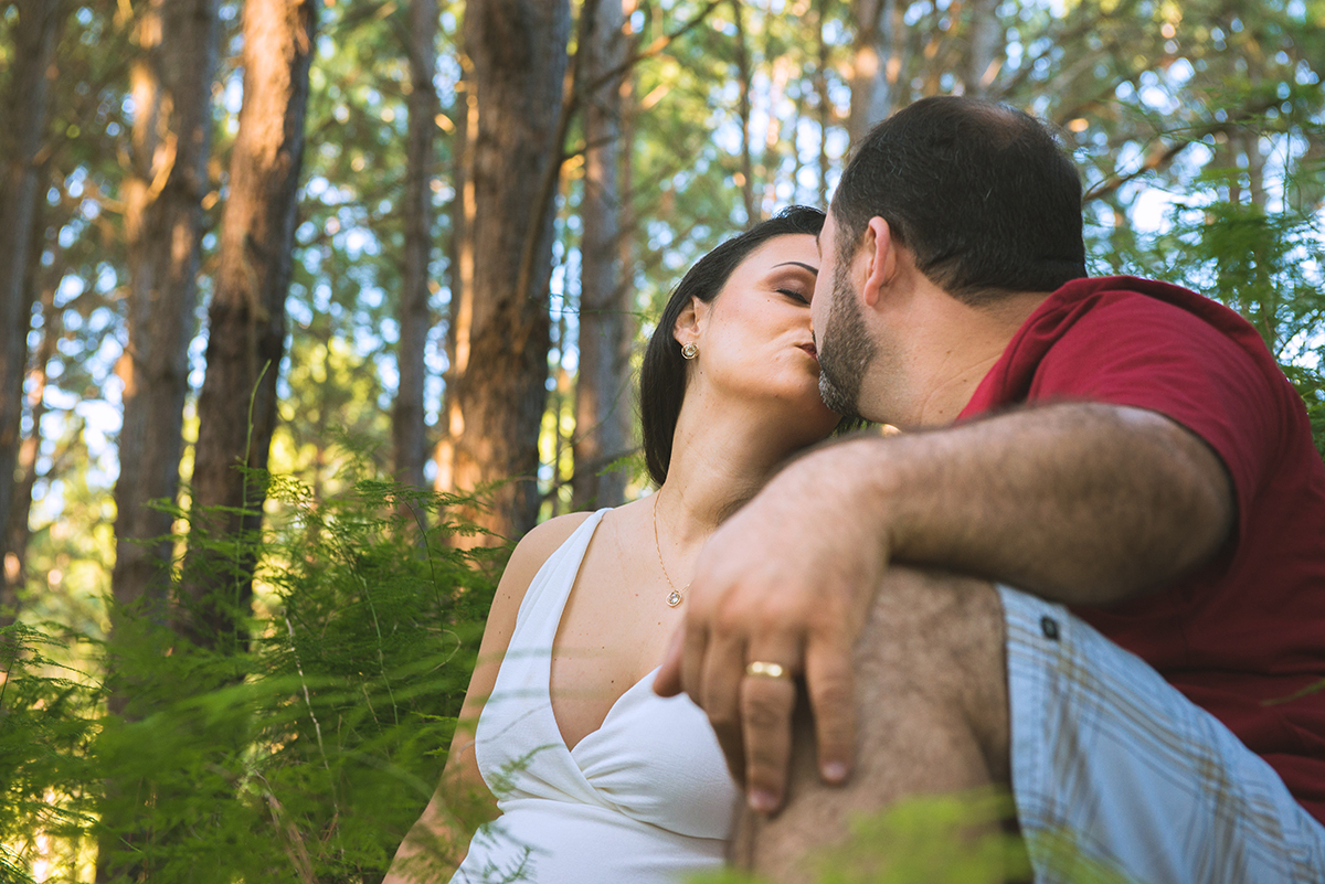 Noivo beija a noiva  em meio a vegetação durante as fotos do seu ensaio de casal pré-wedding. Foto 