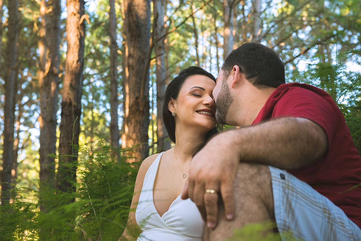 Noivo beija a noiva  em meio a vegetação durante as fotos do seu ensaio de casal pré-wedding. Foto 