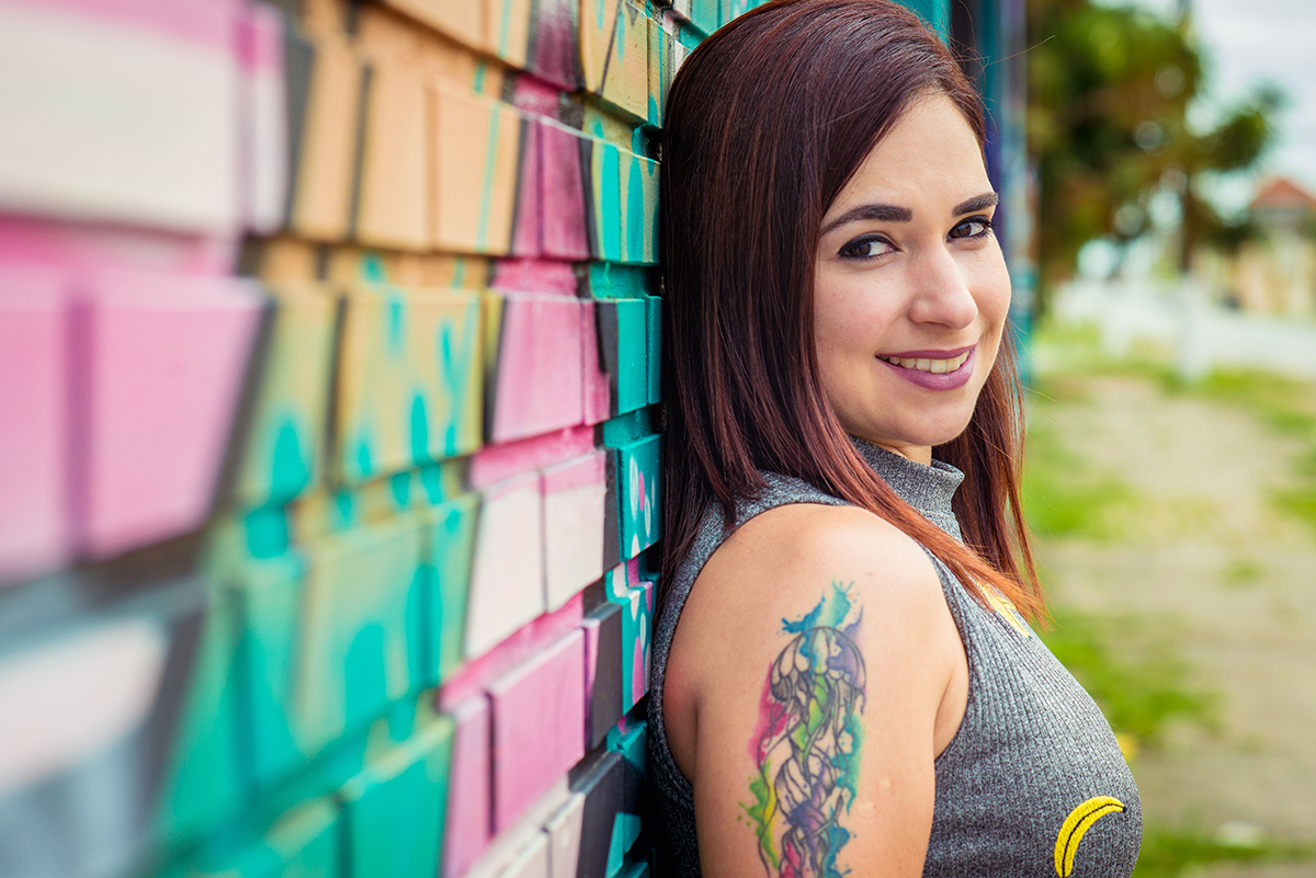 Aniversariante e modelo posando para foto encostada em parede com lindo grafite no porto de Pelotas. Foto por Marco Moscarelli