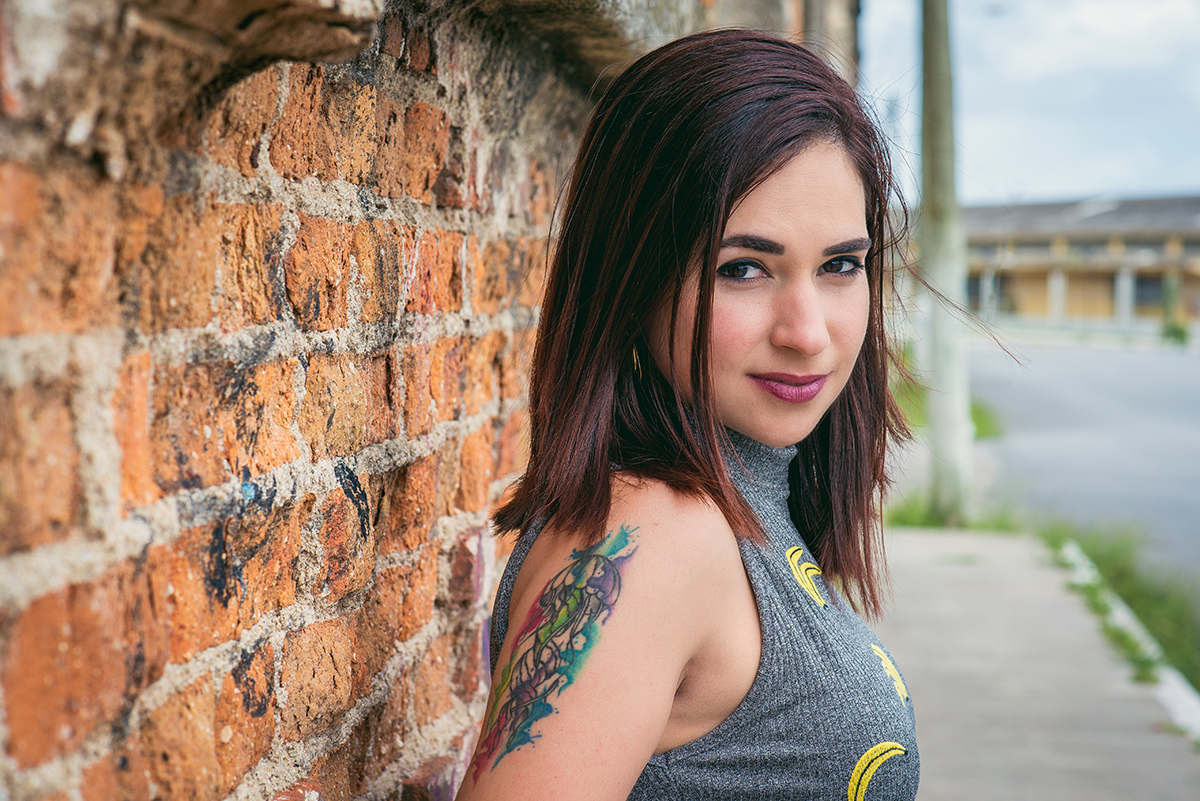 Aniversariante e modelo posando para foto encostada em parede com lindo grafite no porto de Pelotas. Foto por Marco Moscarelli