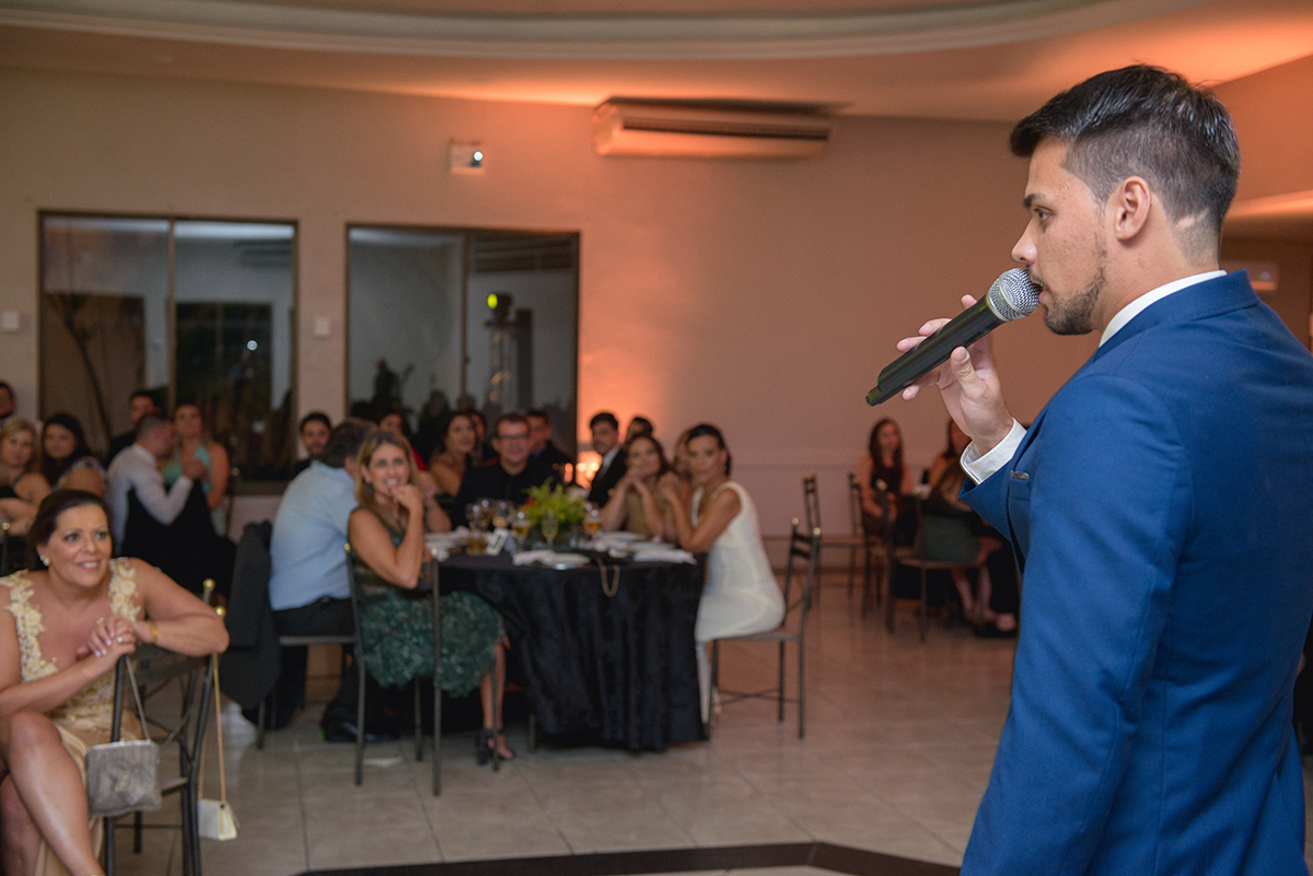 Formando em direito em Pelotas, discursando para seus convidados na recepção de formatura sendo observado pela sua mãe emocionada. Foto por Marco Moscarelli Fotografo.