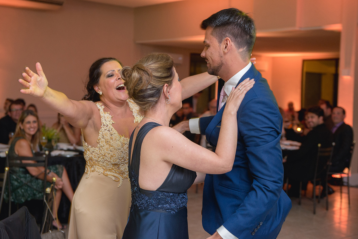 Abraço emocionado da irma e da mãe do formando durante a sua recepção de formatura em Direito em Pelotas. Foto por Marco Moscarelli Fotografo.