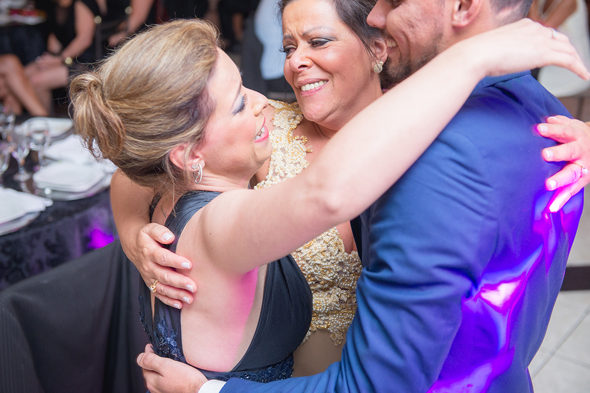 Abraço emocionado da irma e da mãe do formando durante a sua recepção de formatura em Direito em Pelotas. Foto por Marco Moscarelli Fotografo.