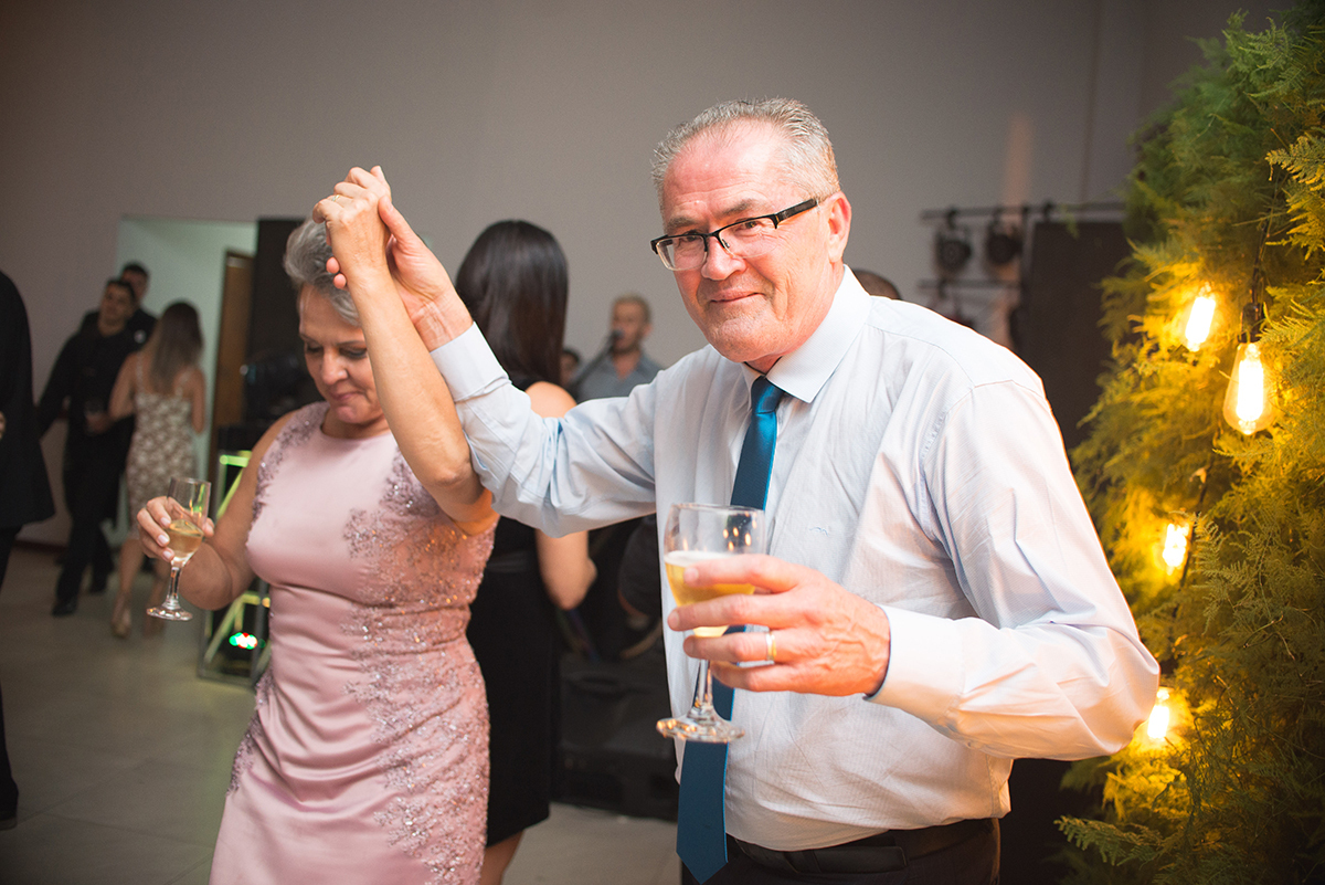 Pais da formanda dançando orgulhoso durante a recepção de formatura. Foto por Marco Moscarelli