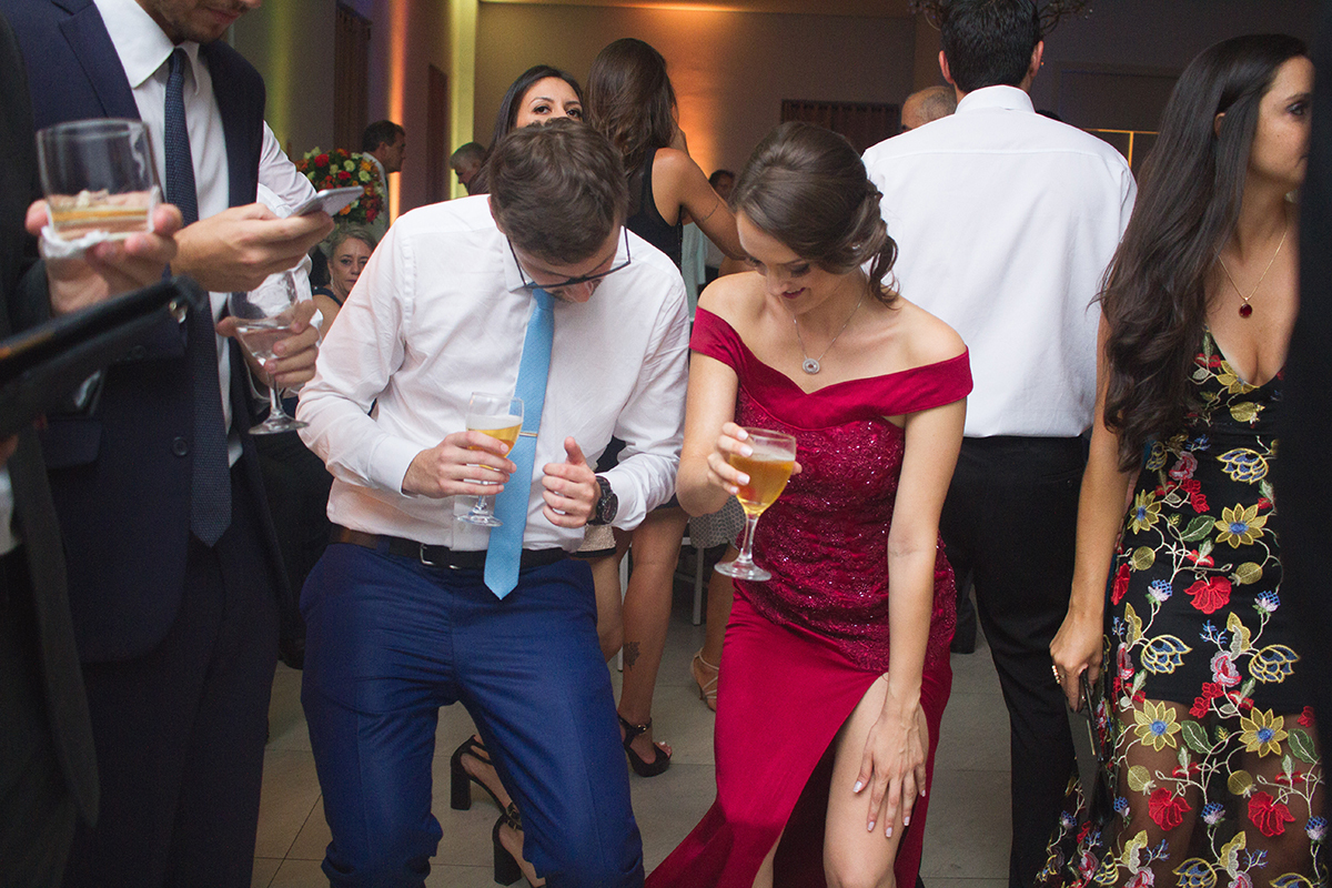 Casal de noivos e formandos dançando alegremente durante a recepção de formatura. Foto por Marco Moscarelli Fotografo.