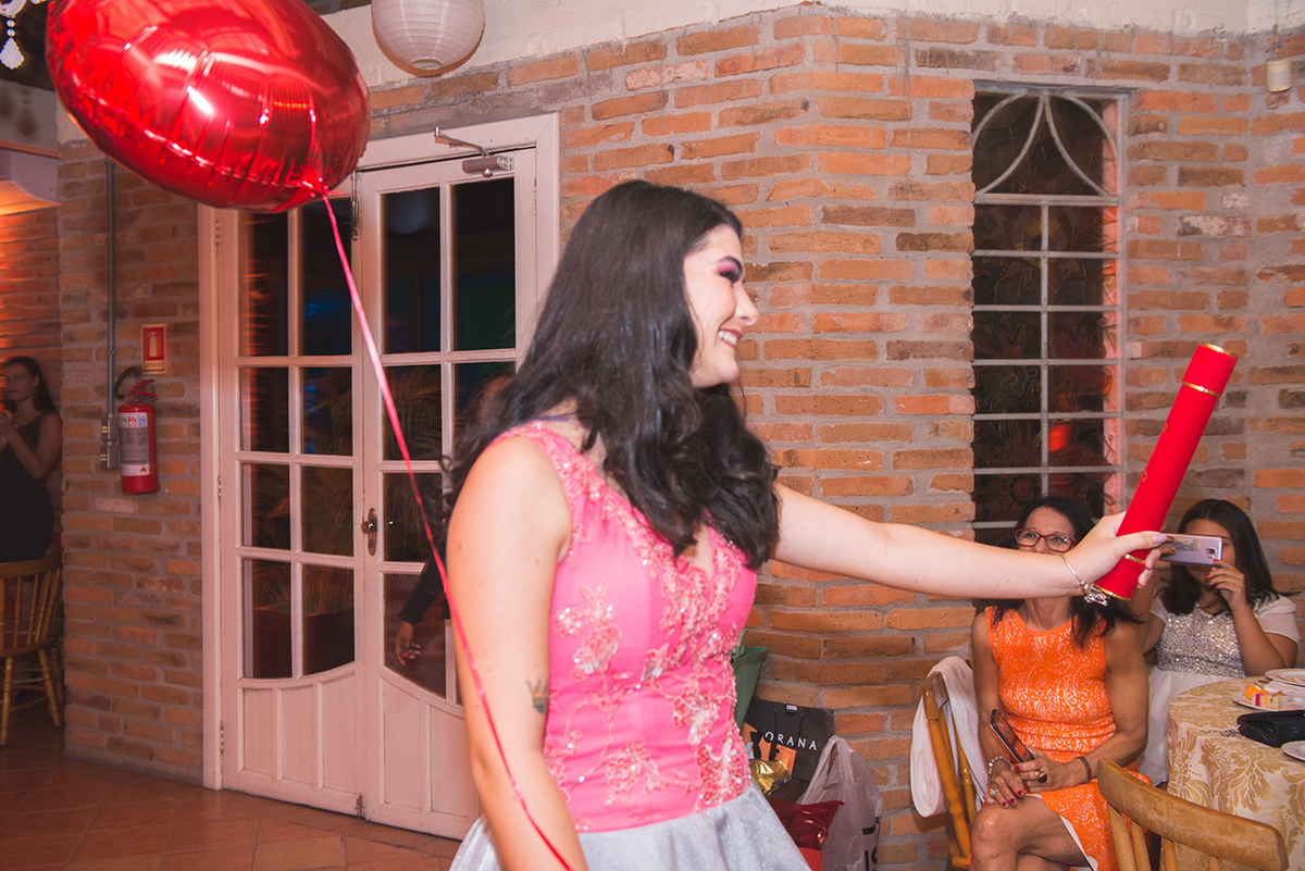 Fotografia do momento da entrada da formanda em jornalismo na sua recepção de formatura. Foto por 