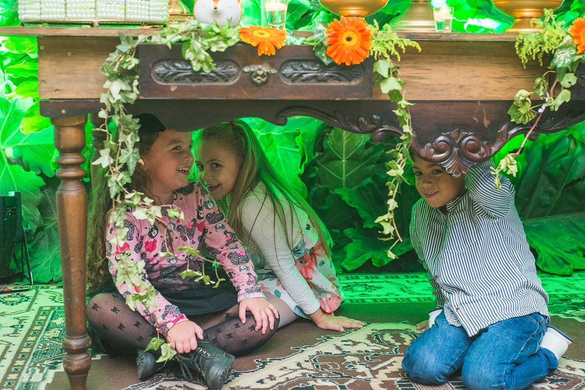 Fotografia engraçada de crianças escondidas embaixo da mesa de doces durante a recepção de formatura. Foto por marco Moscarelli Fotografo.