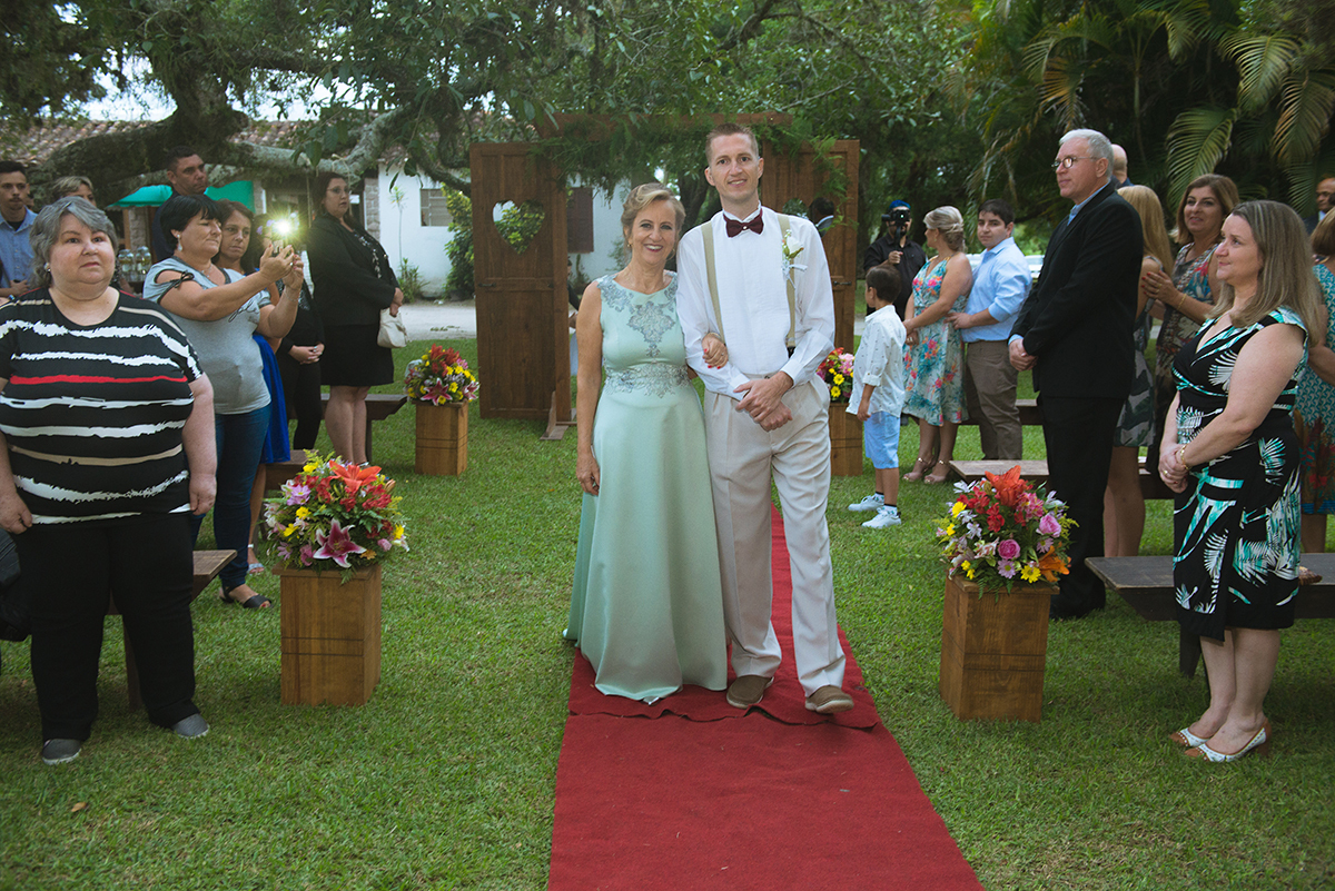 Noivo entrando no local da cerimônia de casamento acompanhando de sua mãe. Foto por Marco Moscarelli.