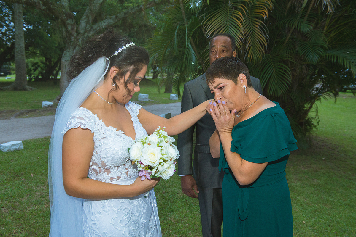 Mãe da noiva beijando a mão emocionada da filha lindamente vestida de branco para o casamento. Foto por marco Moscarelli.