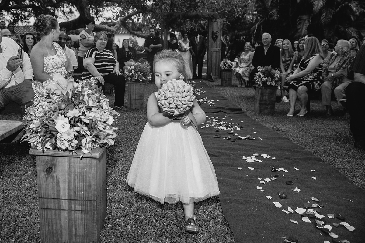 Aia entrando correndo na cerimônia com o buque da noiva na mão. Fotografia em preto e branco por Marco Moscarelli Fotografo