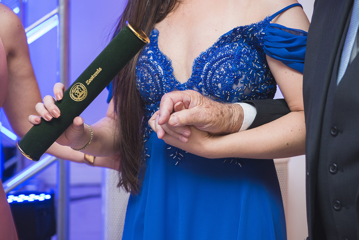 Formanda segurando gentilmente a mão do avô durante seu discurso de formatura. Foto por Marco Moscarelli Fotografo