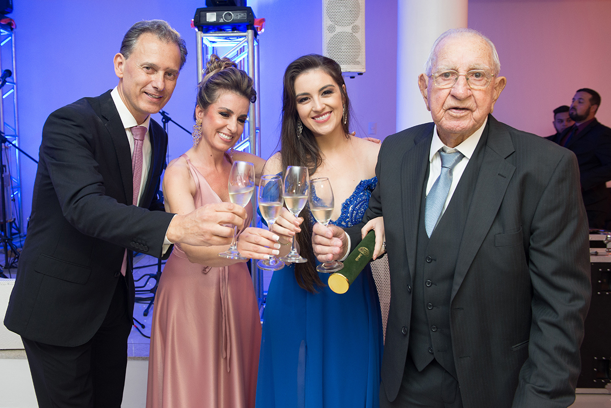 Foto do brinde da formanda com seus pais e avô durante a recepção de formatura. Foto por Marco Moscarelli fotografo.