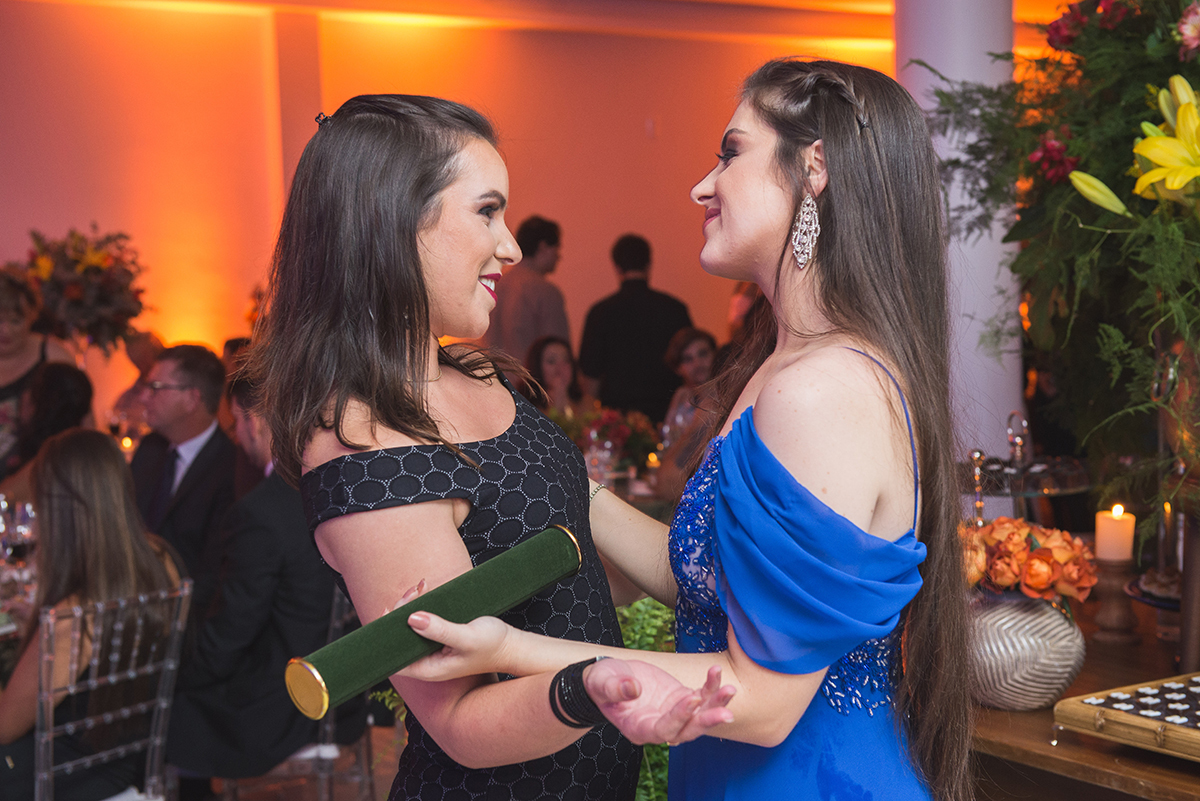 Formanda abraçando uma convidada durante a recepção de formatura. Foto por Marco Moscarelli Fotografo