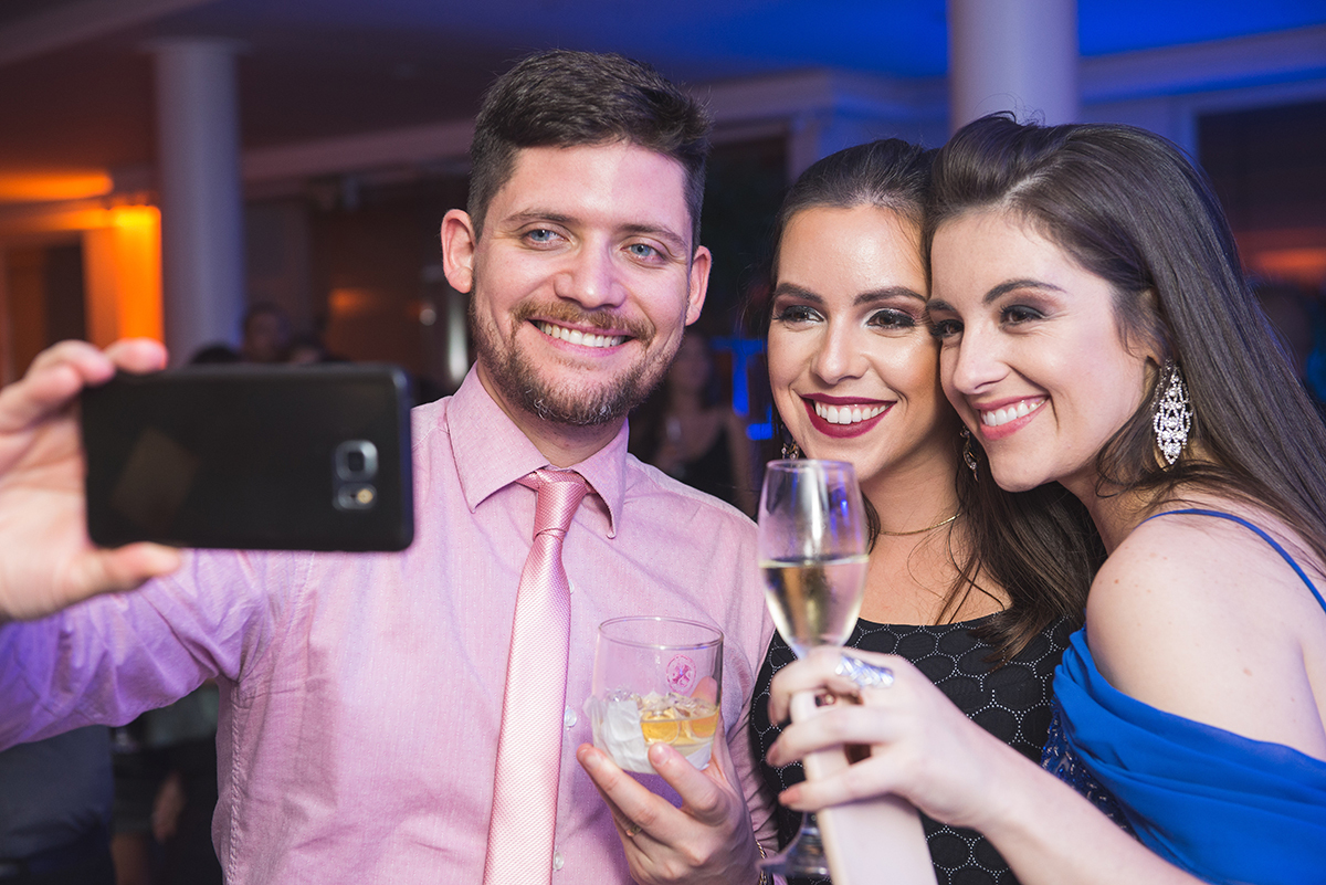 Formanda em uma sefie com convidados durante a recepção de formatura. Foto por Marco Moscarelli