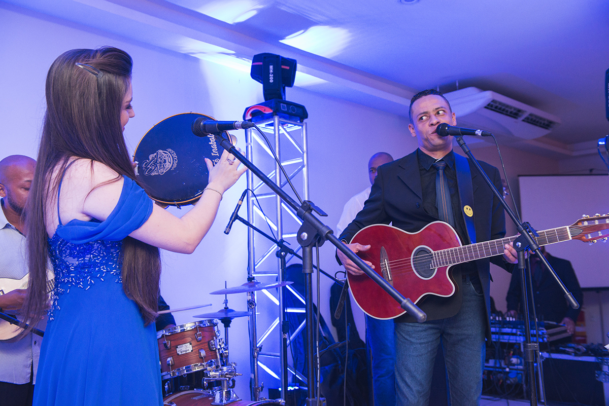 Formanda tocando paneiro em cima do palco durante a sua recepção de formatura. Foto por Marco Moscarelli.