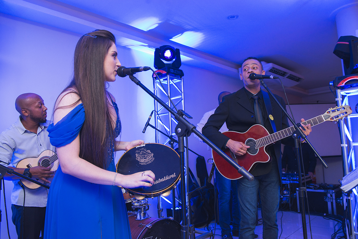 Formanda tocando paneiro em cima do palco durante a sua recepção de formatura. Foto por Marco Moscarelli.
