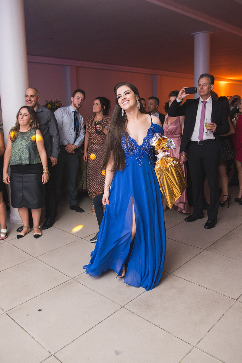 Formanda dançando feliz em seu vestido azul durante a recepção de formatura. Foto por Marco Moscarelli Fotografo
