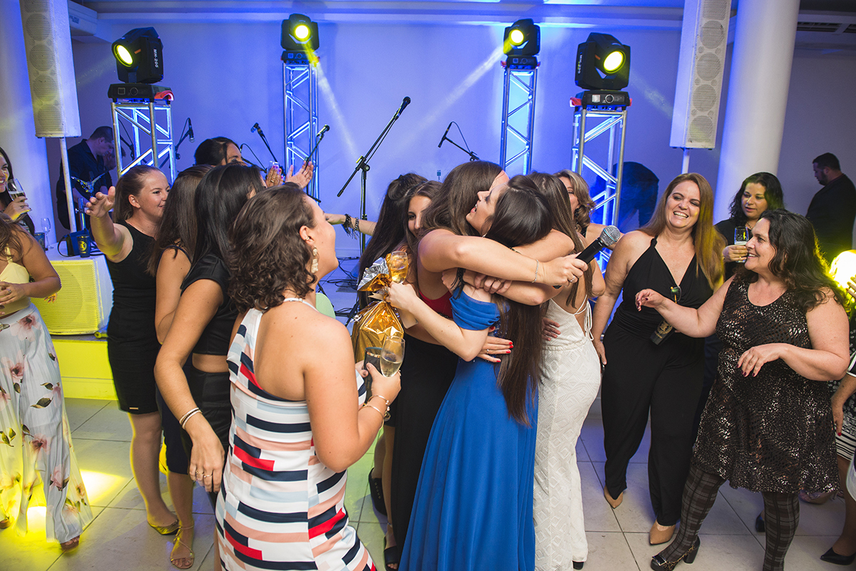Formanda sendo abraçadas pelas convidadas da recepção de formatura. Foto  por Marco Moscarelli Fotografo. 