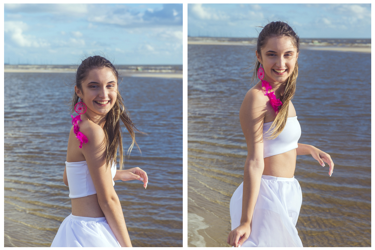 Linda foto da debutante caminhando pela praia com um pequeno barco ao fundo  durante seu ensaio de 15 anos na praia da capilha. Foto por Marco Moscarelli Fotografo.