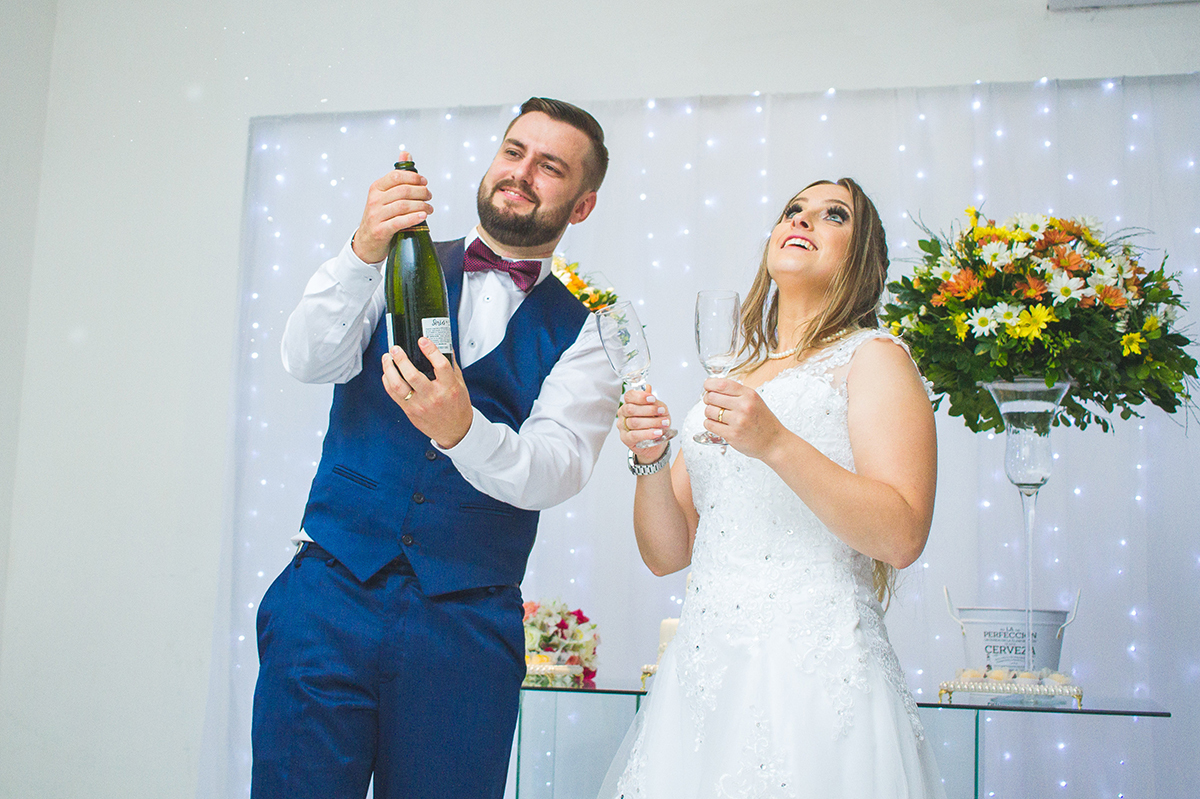 Noivo estourando o espumante na hora do brinde dos noivos. Foto por Marco Moscarelli Fotografo.