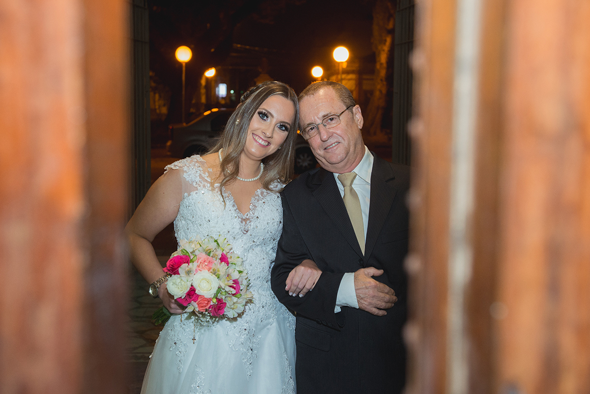Fotografia espontânea da noiva com seu pai prestes a entrar na igreja, fotografados pela fresta da porta da igreja. Foto por Marco Moscarelli Fotografo. 