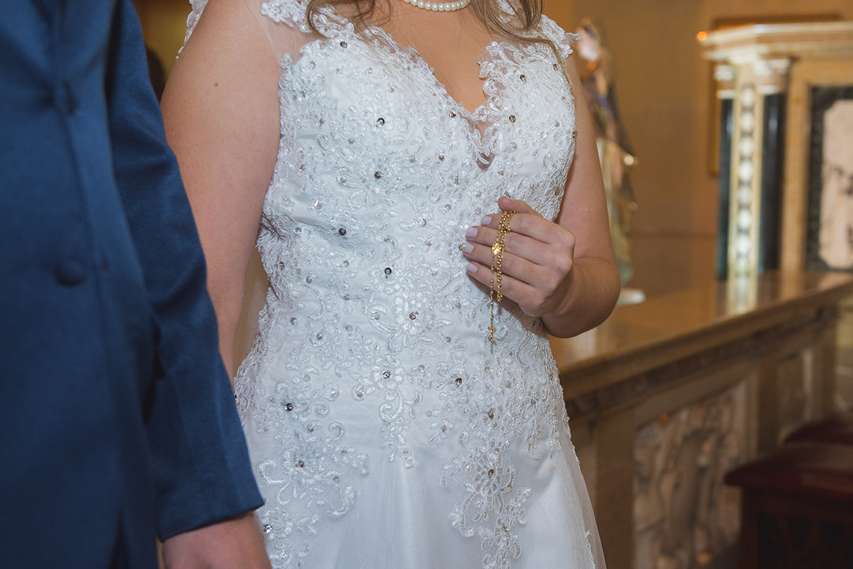 Foto em detalhe do rosário na mão da noiva durante a cerimônia de casamento. Foto por Marco Moscarelli Fotografo.