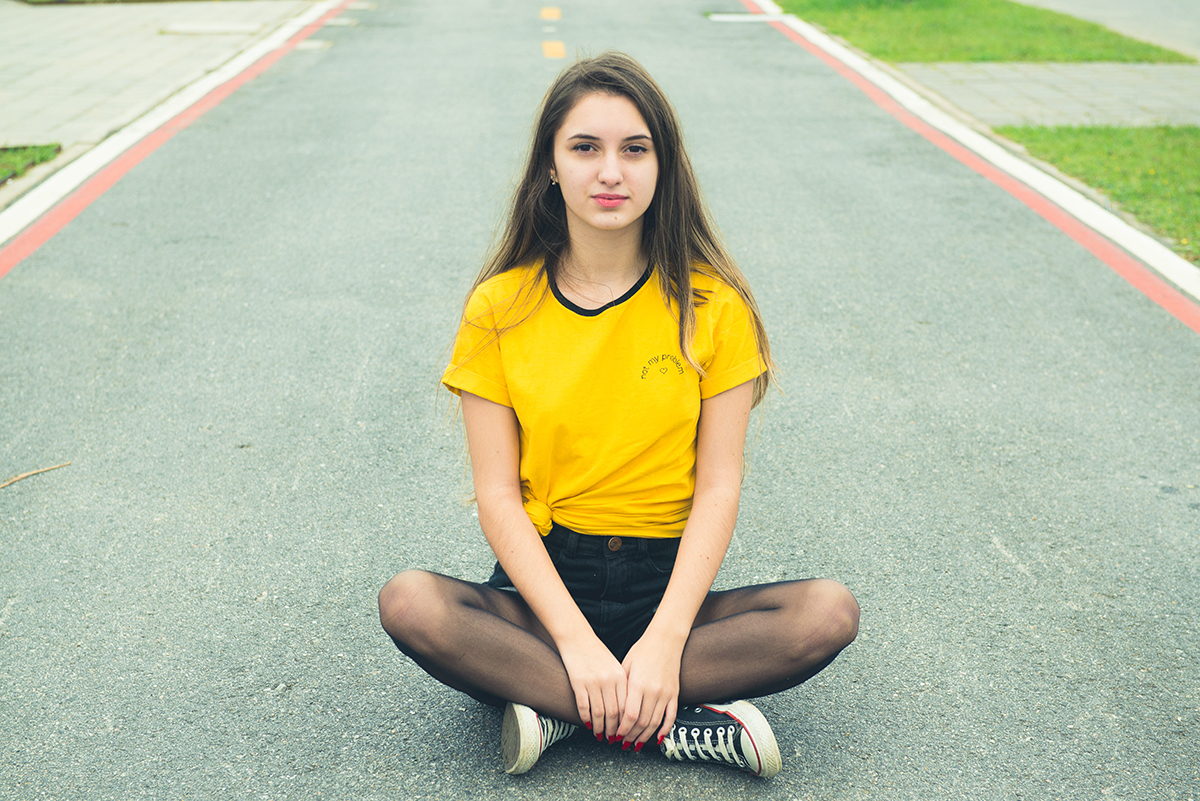 Debutante sentada no meio da rua durante seu ensaio fotográfico de 15 anos. Foto por Marco Moscarelli Fotografo.
