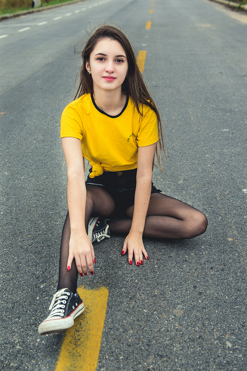 Debutante sentada no meio da rua durante seu ensaio fotográfico de 15 anos. Foto por Marco Moscarelli Fotografo.