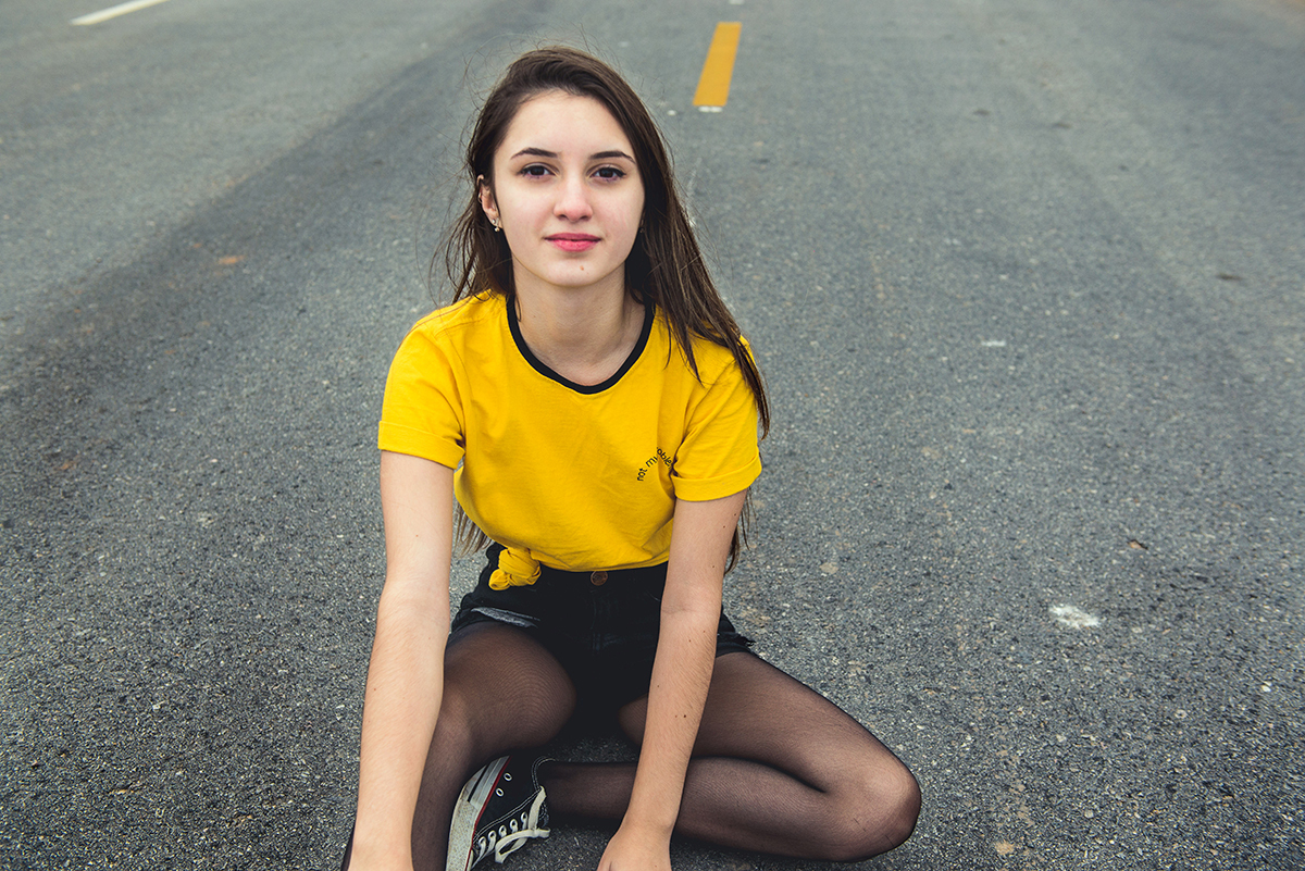 Debutante sentada no meio da rua durante seu ensaio fotográfico de 15 anos. Foto por Marco Moscarelli Fotografo.