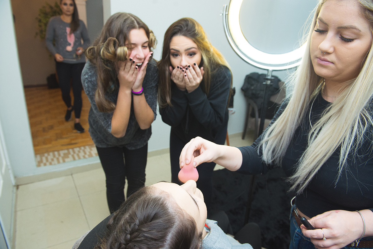 Amigas da debutante olhando admiradas a linda maquiagem da aniversariante para a festa dos 15 anos. Foto por Marco Moscarelli Fotografo.