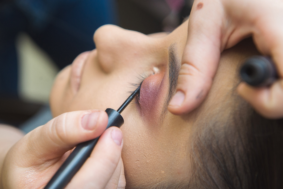 Maquiadora colocando rímel durante a maquiagem da debutante. Foto por Marco Moscarelli Fotografo.