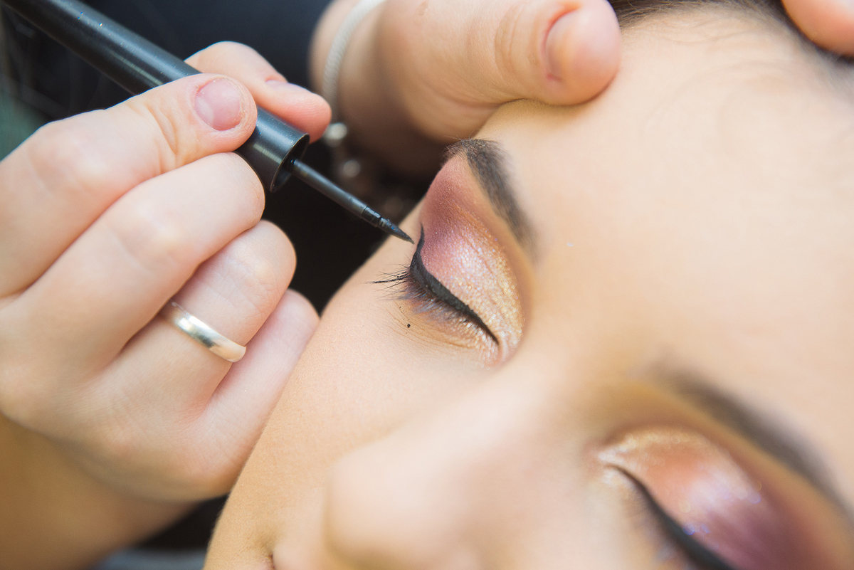 Maquiadora colocando rímel durante a maquiagem da debutante. Foto por Marco Moscarelli Fotografo.