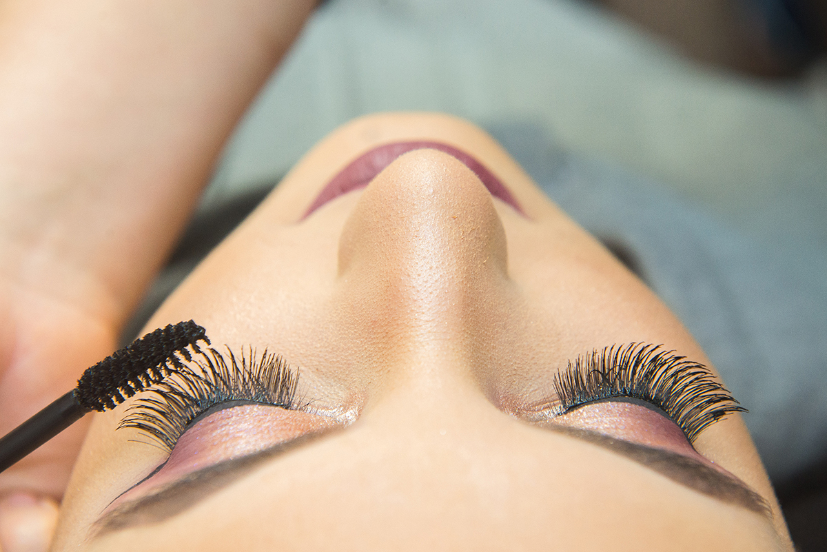 Maquiadora colocando rímel durante a maquiagem da debutante. Foto por Marco Moscarelli Fotografo.