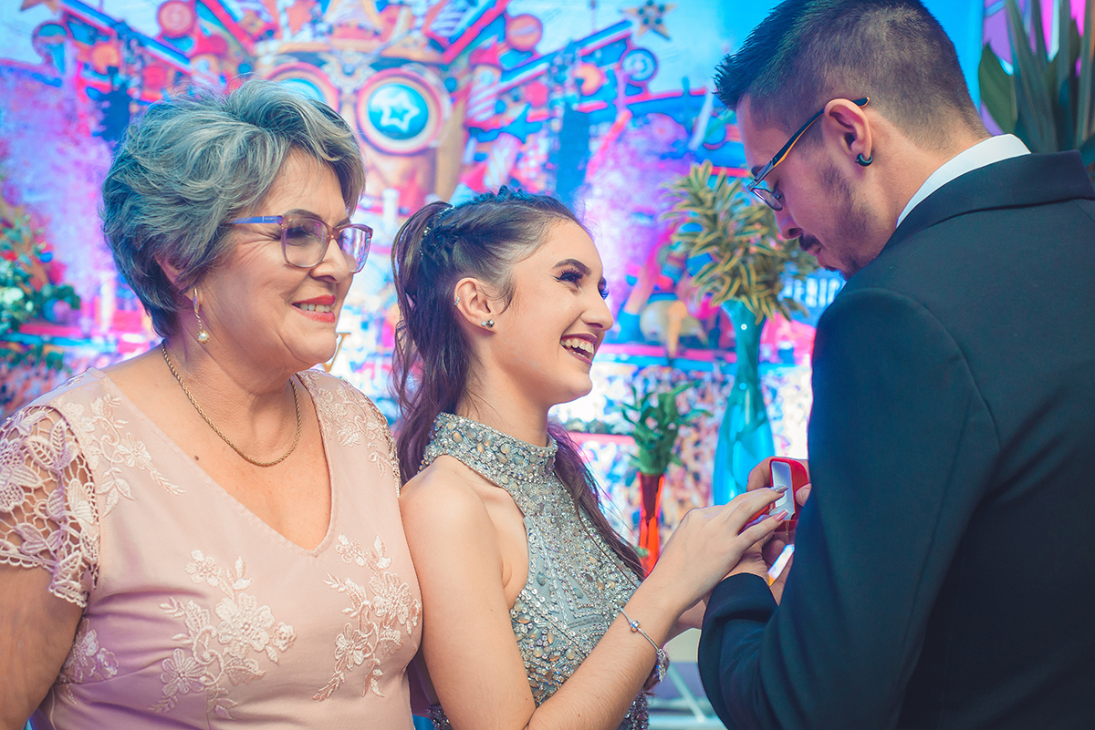 Linda foto do momento em que a aniversariante recebe um anel de 15 anos do seu padrinho, durante a festa de 15 anos. Foto por Marco Moscarelli Fotografo.