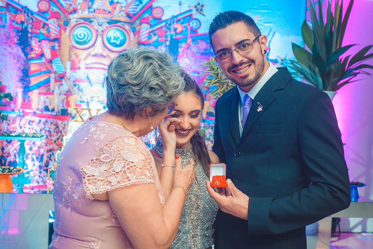 Linda foto do momento em que a aniversariante recebe um anel de 15 anos do seu padrinho, durante a festa de 15 anos. Foto por Marco Moscarelli Fotografo.