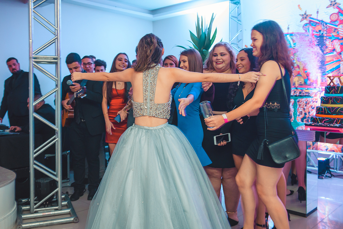 Debutante corre de braços abertos para abraçar seus amigos logo após os videos de homenagens nos seus 15 anos. Foto por Marco Moscarelli Fotografo.