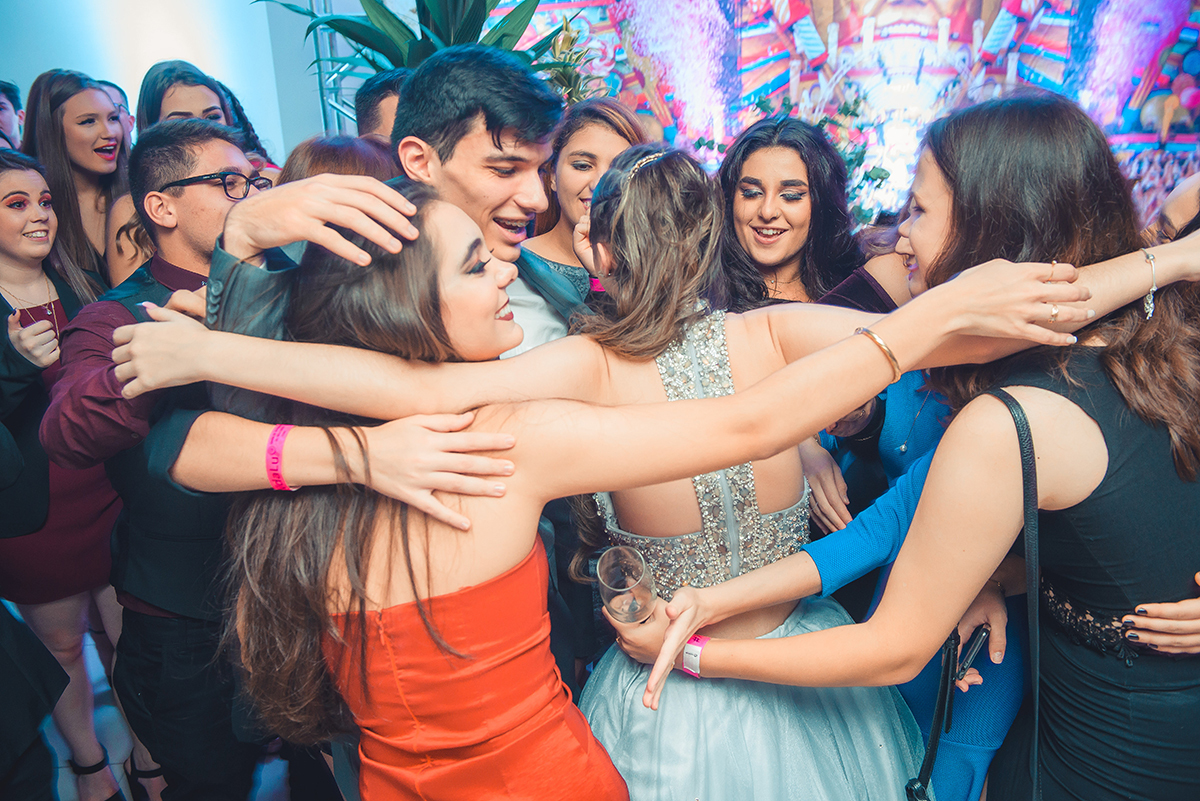 Debutante corre de braços abertos para abraçar seus amigos logo após os videos de homenagens nos seus 15 anos. Foto por Marco Moscarelli Fotografo.