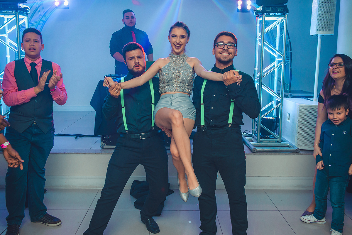 Debutante abrindo a pista de dança sendo carregada por dois convidados durante o seu aniversário de 15 anos. Foto por Marco Moscarelli 