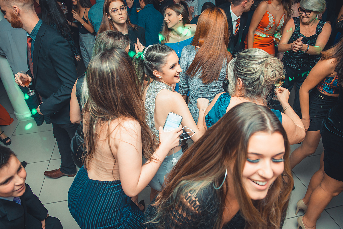 Aniversariante dançando alegremente com seus convidados durante a sua festa de 15 anos. Foto por Marco Moscarelli Fotografo.