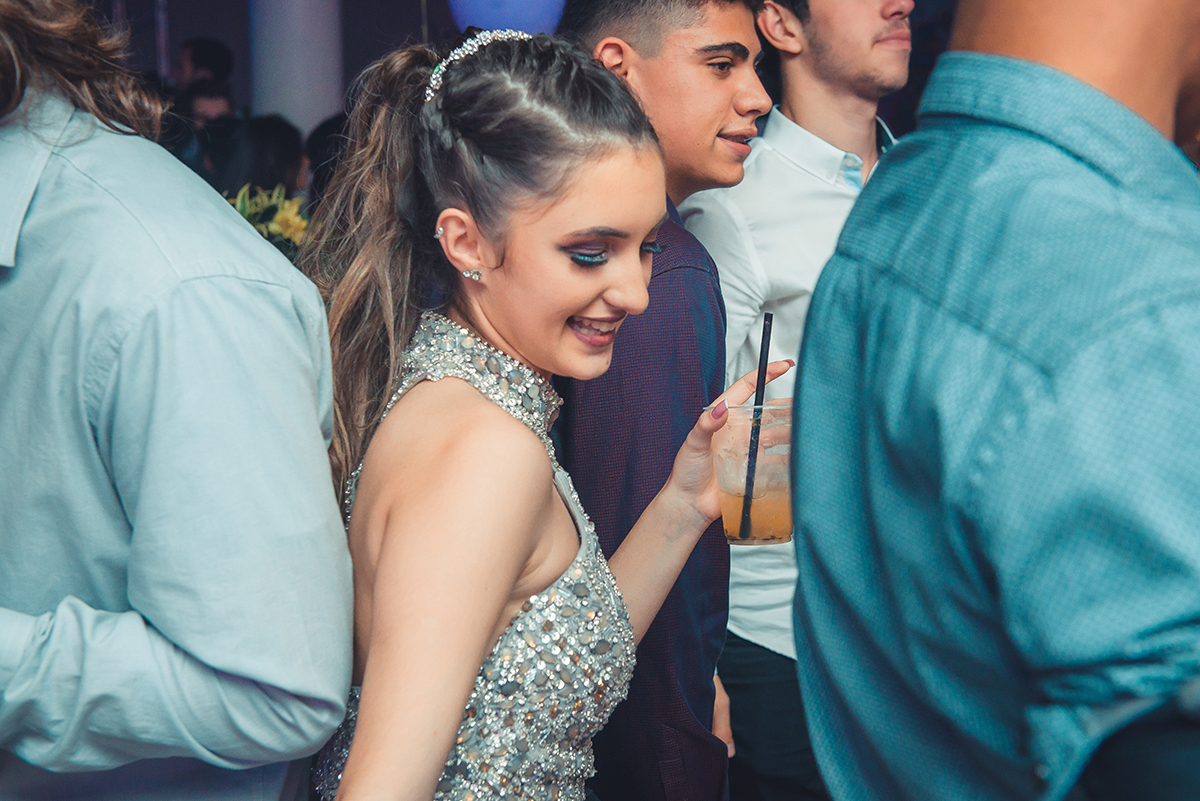 Aniversariante dançando alegremente com seus convidados durante a sua festa de 15 anos. Foto por Marco Moscarelli Fotografo.