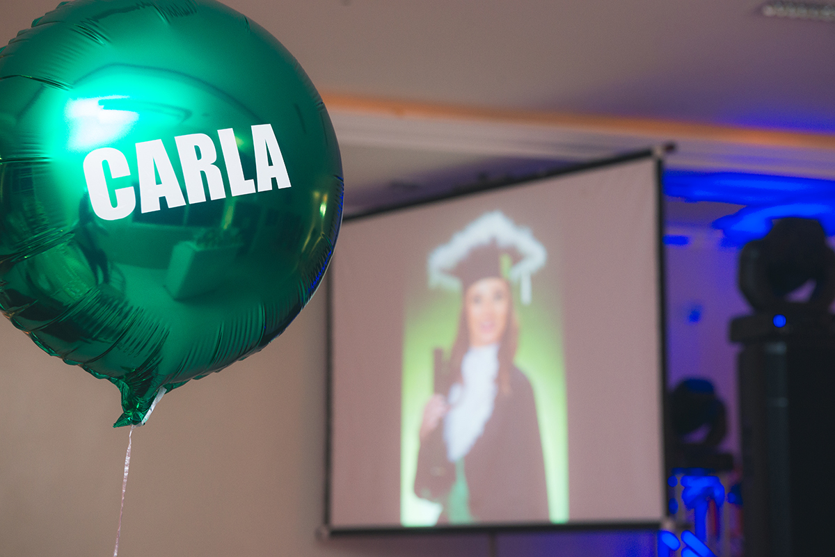 Fotografia autoral do balão com o nome da formanda e sua foto ao fundo no telão que decora a recepção de formatura em Medicina em pelotas. Foto por marco Moscarelli Fotografo