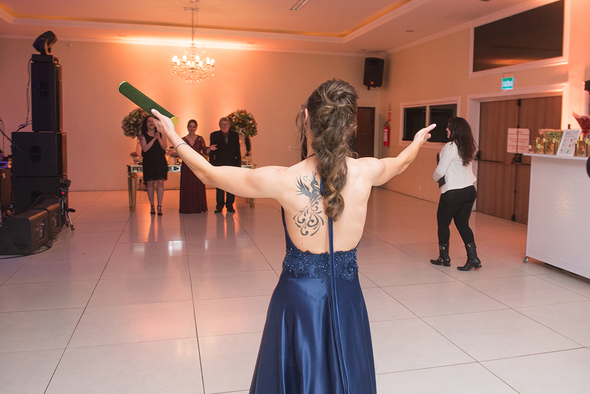 Formanda do curso de medicina entrando no salão com os braços abertos. Foto por marco Moscarelli Fotografo.