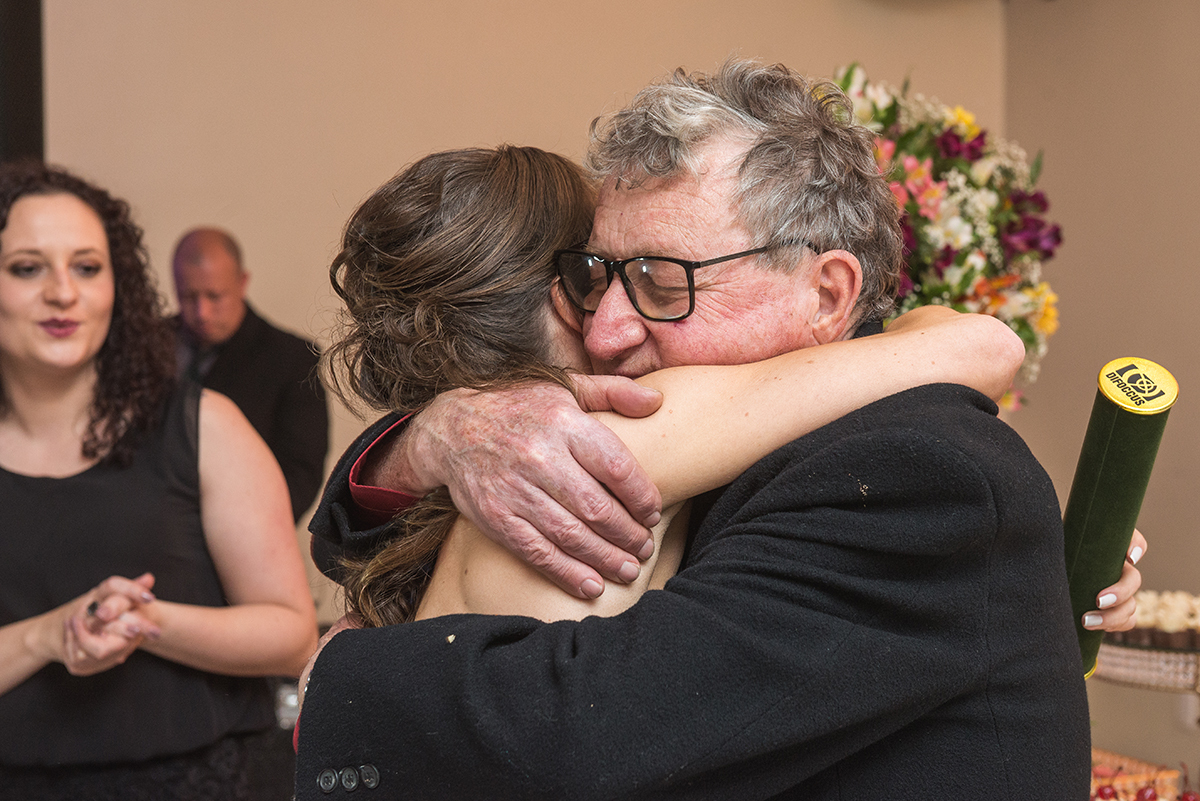 Formanda em medicina abraçando seu pai logo na sua entrada no salão da recepção de formatura. foto por Marco Moscarelli fotografo.